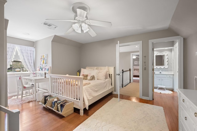 bedroom featuring lofted ceiling, wood finished floors, visible vents, and a ceiling fan