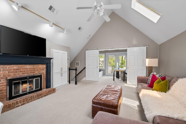 living area featuring visible vents, a ceiling fan, and high vaulted ceiling
