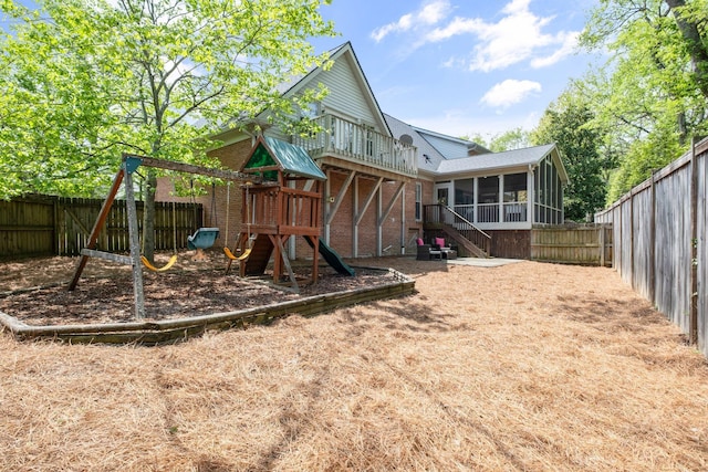 view of play area with a sunroom and a fenced backyard