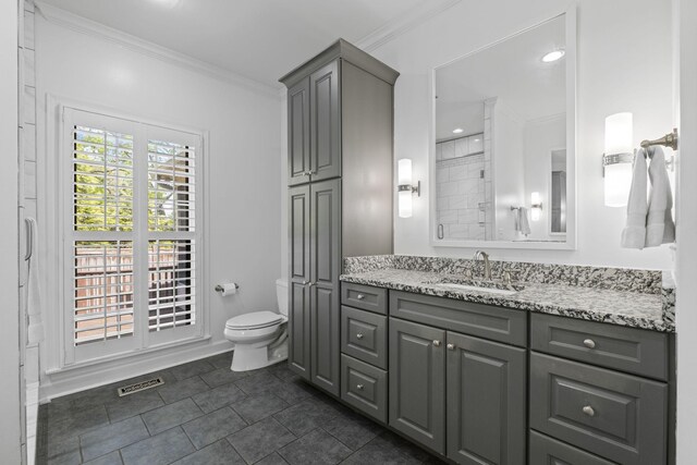 bathroom with toilet, crown molding, visible vents, and vanity