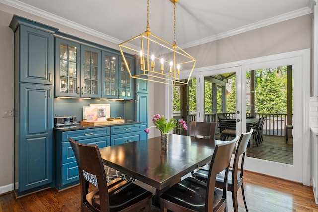dining room with a chandelier, dark wood finished floors, french doors, and crown molding