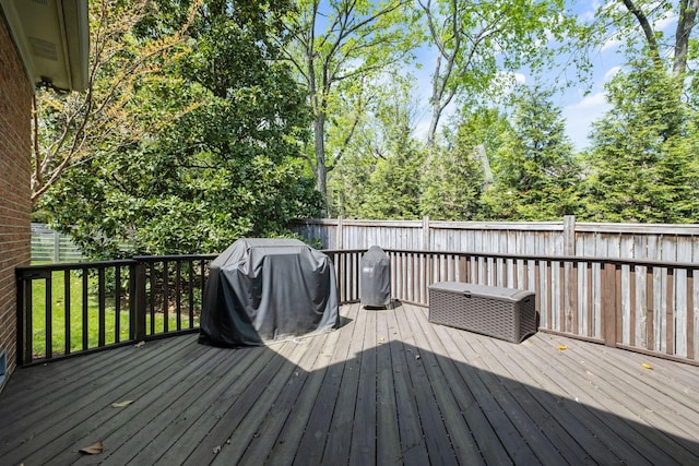 wooden terrace with a grill and fence