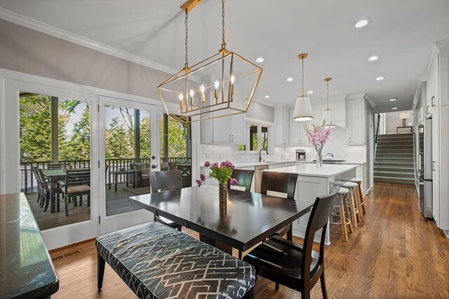 dining space with recessed lighting, a notable chandelier, dark wood-type flooring, crown molding, and visible vents