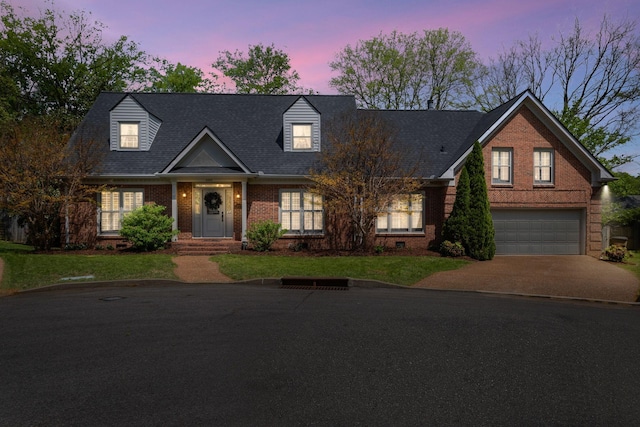 cape cod home with driveway, a front lawn, brick siding, and a garage