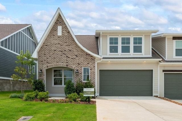 view of front of house with roof with shingles, concrete driveway, a front yard, and an attached garage
