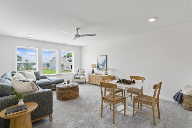 living area featuring visible vents, ceiling fan, and carpet floors