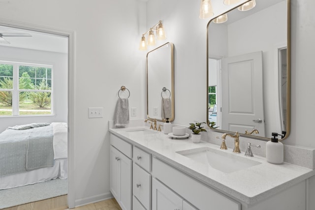 ensuite bathroom with ceiling fan, ensuite bath, double vanity, and a sink