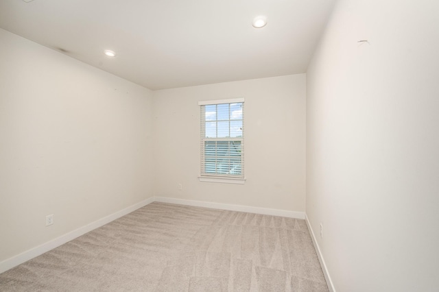 spare room featuring recessed lighting, baseboards, and light carpet