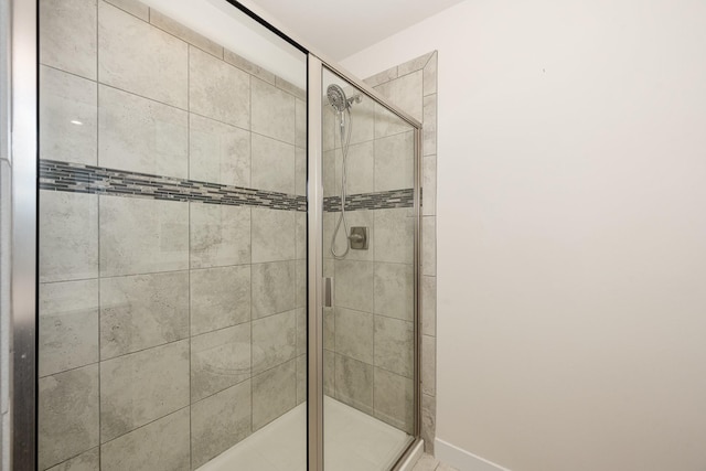 bathroom featuring baseboards and a stall shower
