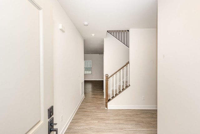 hallway with recessed lighting, baseboards, wood finished floors, and stairway