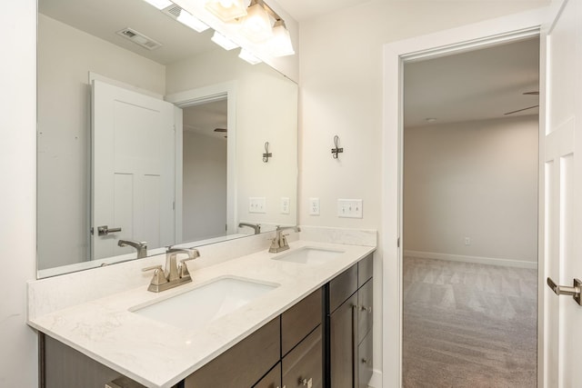 bathroom featuring visible vents, a sink, baseboards, and double vanity