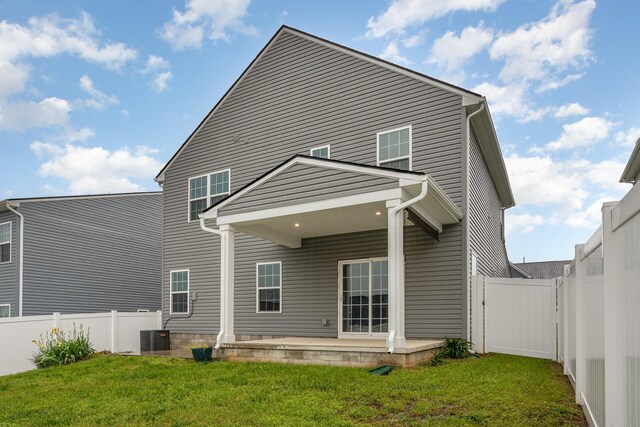 back of house featuring a lawn, a patio, and a fenced backyard