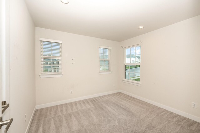 carpeted empty room featuring recessed lighting and baseboards