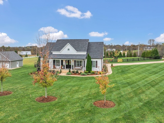 view of front of home with fence, roof with shingles, a porch, and a front lawn