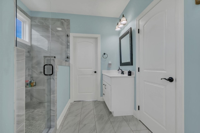 bathroom featuring marble finish floor, vanity, a stall shower, and baseboards