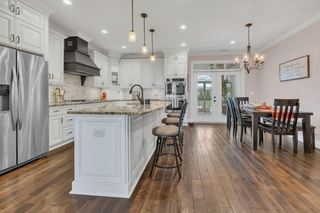kitchen featuring premium range hood, white cabinets, and appliances with stainless steel finishes