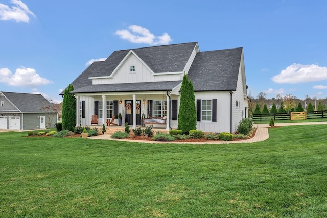 view of front of house with fence, board and batten siding, a porch, and a front yard