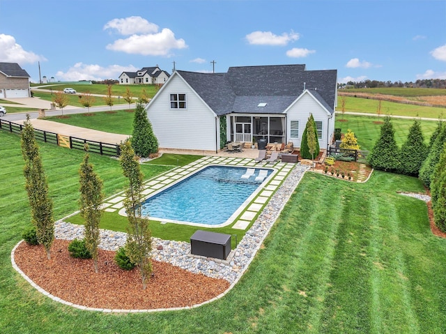 pool featuring a patio, outdoor lounge area, a sunroom, a yard, and a fenced backyard