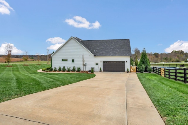 view of home's exterior with a yard, fence, driveway, roof with shingles, and an attached garage
