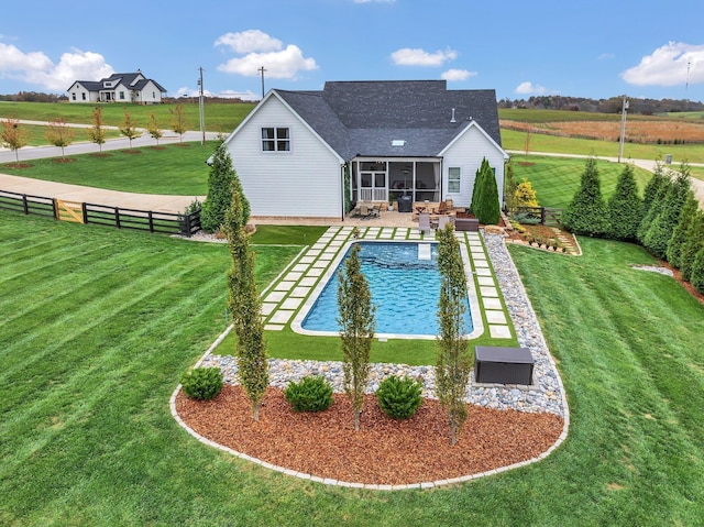 view of swimming pool featuring a fenced in pool, a sunroom, a lawn, and a fenced backyard