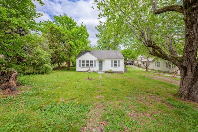view of front of house featuring entry steps and a front lawn