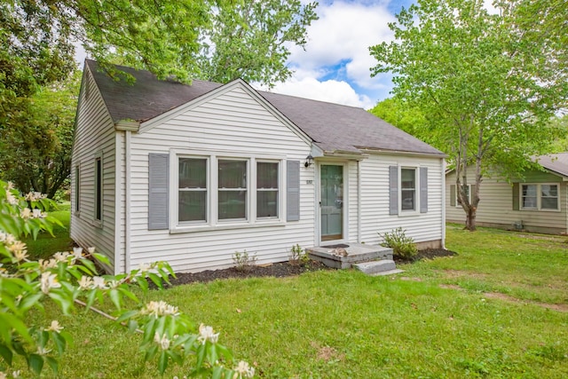 bungalow-style house with a shingled roof and a front lawn