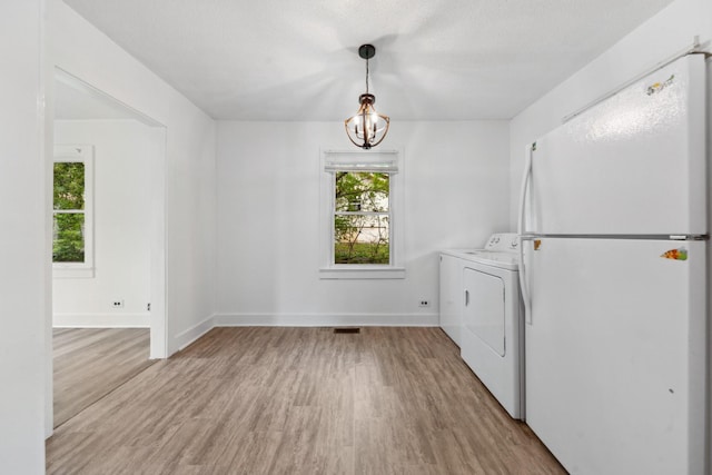 laundry area featuring visible vents, separate washer and dryer, light wood finished floors, a notable chandelier, and laundry area