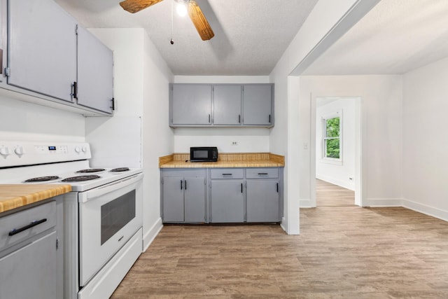 kitchen with gray cabinets, light wood-style flooring, white range with electric cooktop, black microwave, and a ceiling fan