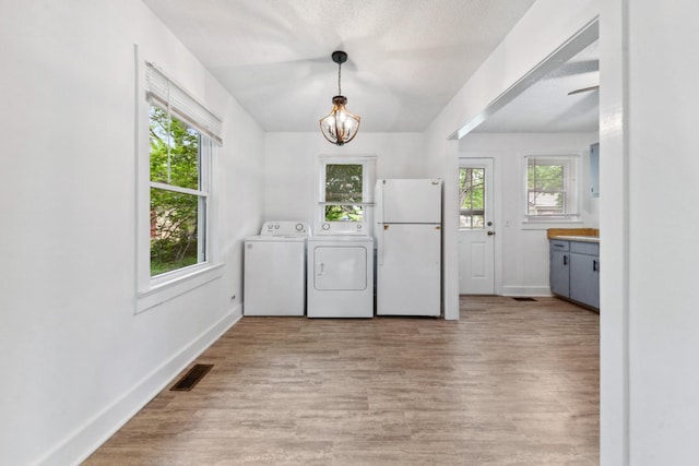 laundry room featuring baseboards, visible vents, a healthy amount of sunlight, and separate washer and dryer