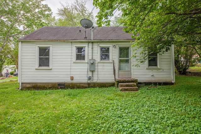 back of property with a lawn and entry steps