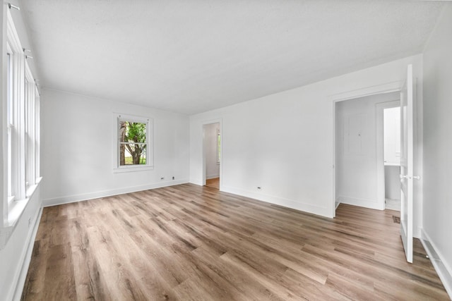 unfurnished living room featuring baseboards and light wood-type flooring