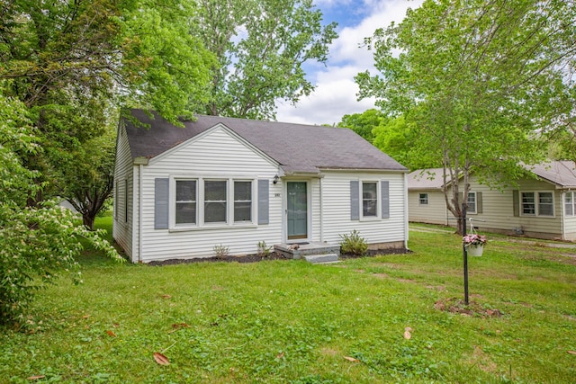 bungalow with a shingled roof and a front yard
