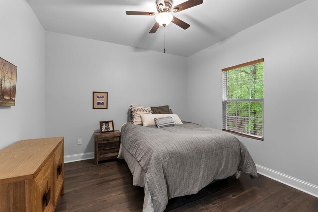 bedroom with dark wood-style flooring, ceiling fan, and baseboards