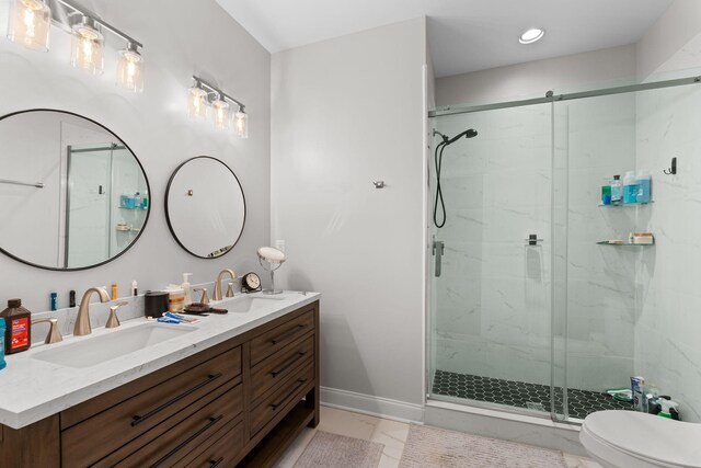 bathroom with double vanity, toilet, a stall shower, and a sink