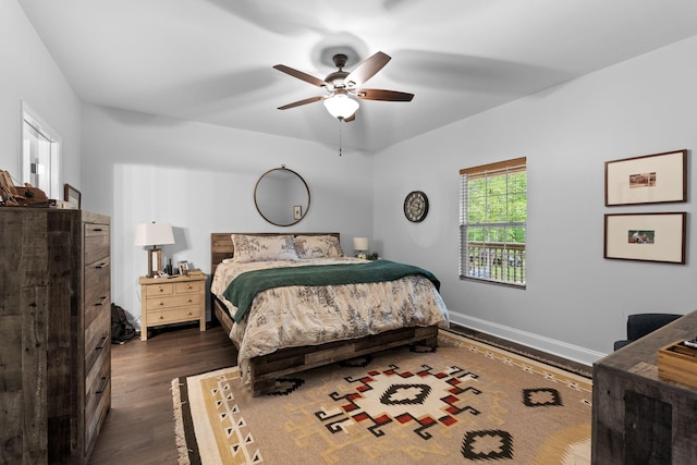 bedroom with baseboards, a ceiling fan, and dark wood-type flooring