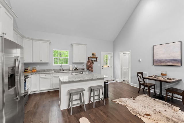 kitchen featuring appliances with stainless steel finishes, white cabinetry, a kitchen island, and a sink
