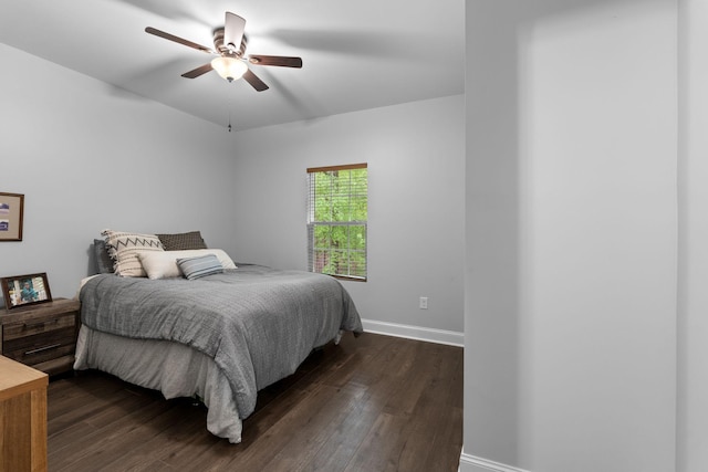 bedroom with baseboards, a ceiling fan, and dark wood-style flooring