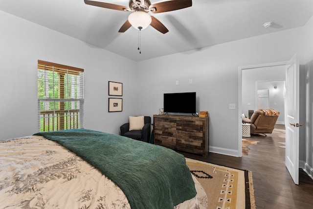 bedroom with a ceiling fan, wood finished floors, and baseboards