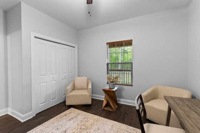 sitting room with baseboards and dark wood-type flooring