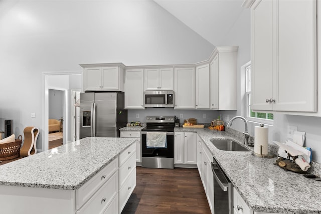 kitchen featuring a sink, high vaulted ceiling, white cabinetry, a kitchen island, and appliances with stainless steel finishes