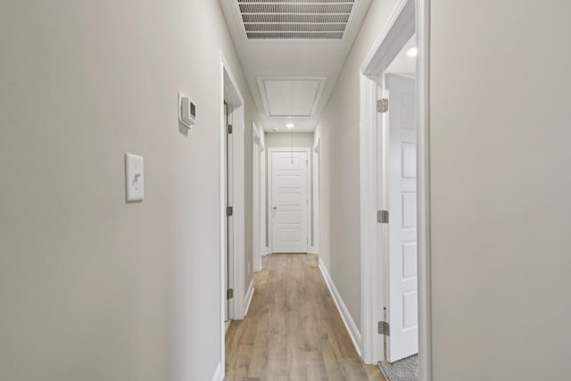 corridor with attic access, recessed lighting, light wood-style floors, visible vents, and baseboards