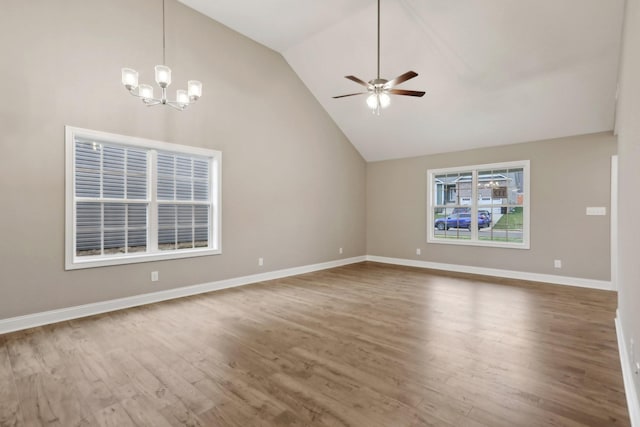 unfurnished living room featuring wood finished floors, baseboards, vaulted ceiling, and ceiling fan with notable chandelier