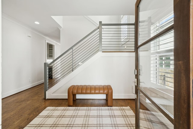 stairway featuring a wealth of natural light, wood finished floors, and baseboards