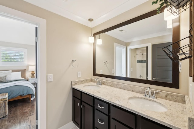 bathroom featuring double vanity, a sink, wood finished floors, and baseboards