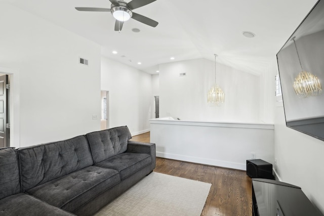 living area with high vaulted ceiling, visible vents, baseboards, wood finished floors, and ceiling fan with notable chandelier