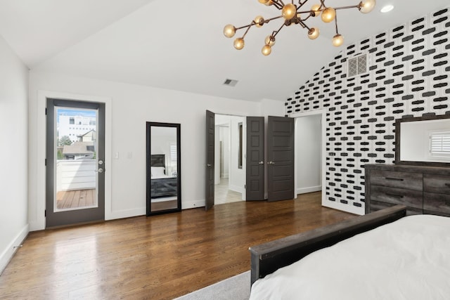 unfurnished bedroom featuring visible vents, baseboards, vaulted ceiling, wood finished floors, and a notable chandelier