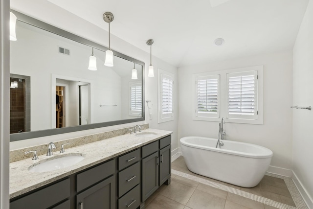 full bathroom featuring a freestanding tub, visible vents, baseboards, and a sink