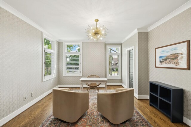 living area featuring wood finished floors, ornamental molding, and wallpapered walls