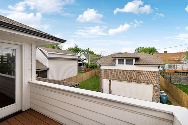 wooden deck featuring a detached garage and a fenced backyard