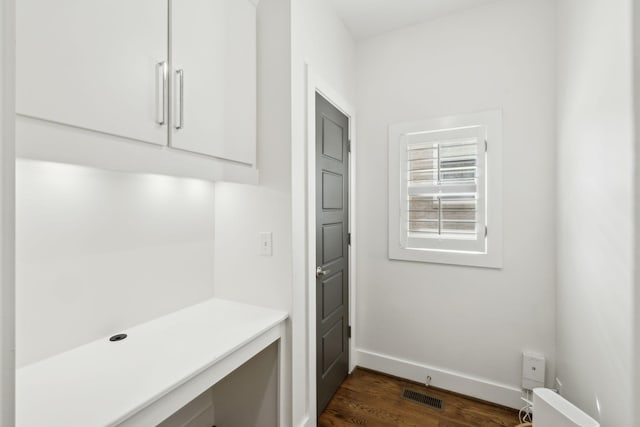 mudroom featuring dark wood-type flooring, visible vents, and baseboards